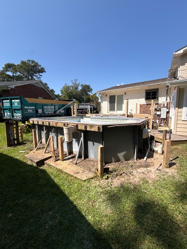 Old wooden deck and above-ground pool in a backyard in Wilmington, NC, before removal