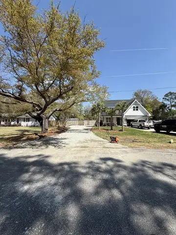 Driveway cut and prepped for gravel beside a live oak