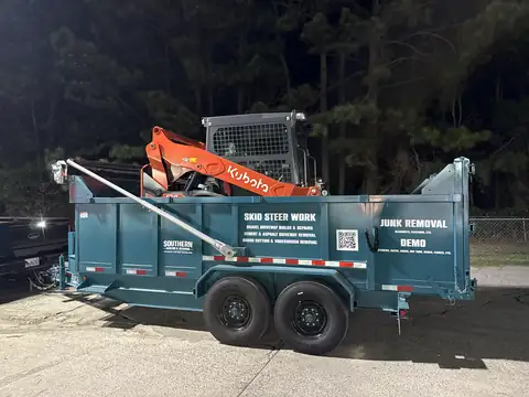 Southern Hauling and Clearing dump trailer lettered for skid steer work, junk removal and demo, with the Kubota track loader