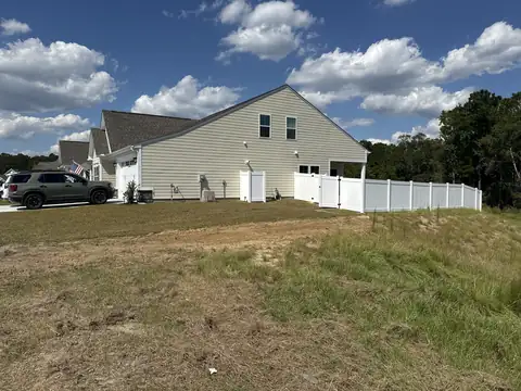 Graded yard beside a house with new grass coming in