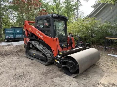 Kubota track loader with a smooth drum roller attachment