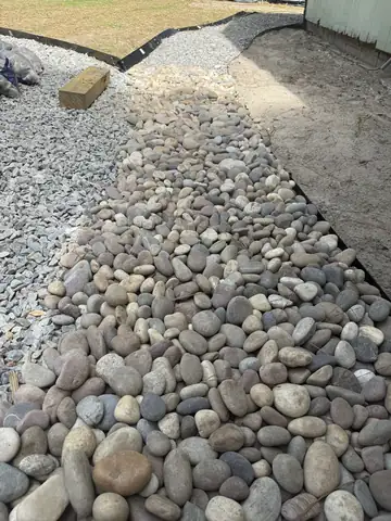 New river rock and gravel bed edged along a yard