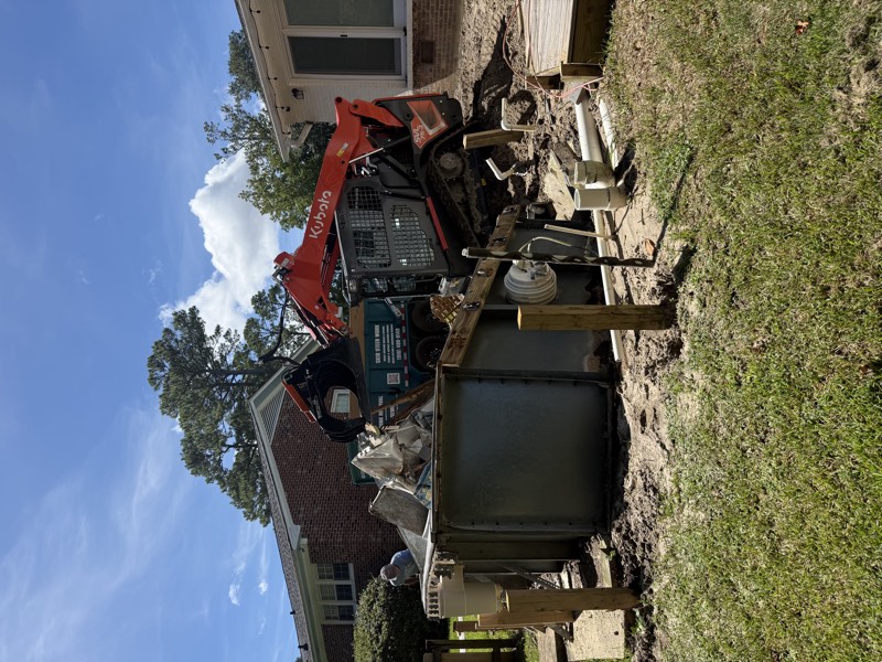 Kubota track loader tearing out an above-ground pool beside a house in Wilmington, NC