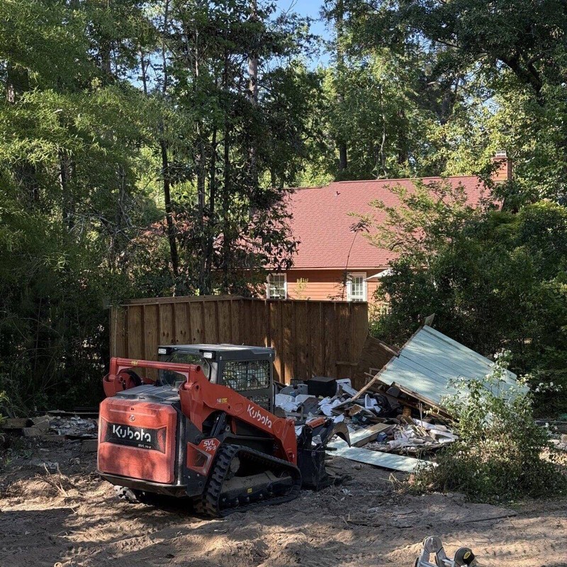 Kubota track loader next to shed demolition debris in Wilmington NC
